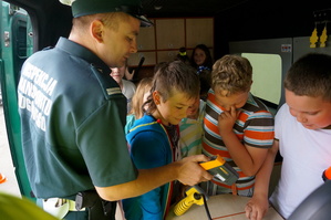 inspektor prezentuje uczniom wyposażenie radiowozu Inspekcji Transportu Drogowego