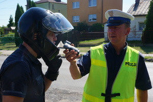 Policjant ruchu drogowego sprawdza stan trzeźwości motocyklisty