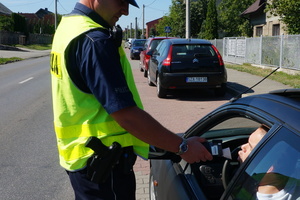 Policjant ruchu drogowego sprawdza stan trzeźwości kierowcy osobówki