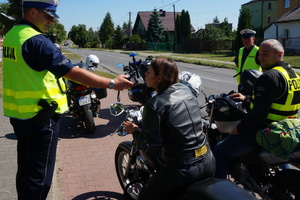 Policjant ruchu drogowego sprawdza stan trzeźwości motocyklistki