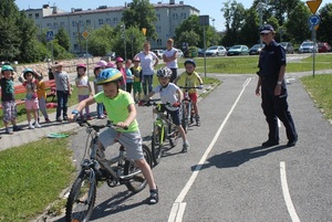 Policjant na placu manewrowym z dziećmi na rowerach