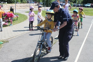 Policjant pomaga utrzymać równowagę dziecku na rowerze