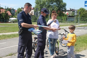 Przedszkolanka i policjanci przekazują dziecku opaskę odblaskową i dyplom