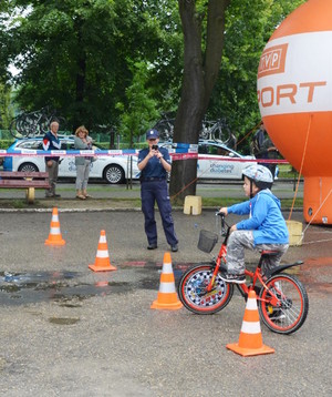 Policjantka obserwuje slalom, który pokonuje chłopiec na rowerze