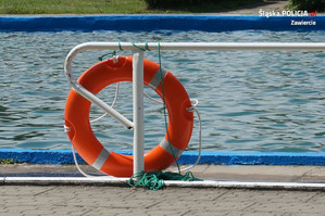 Czerwone koło ratunkowe na tle basenu z wodą.
