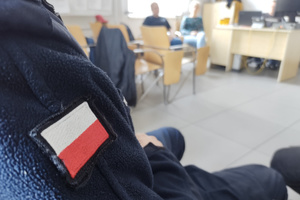 Na zdjęciu widoczna naszywka w postaci polskiej flagi, na rękawie munduru policjanta.