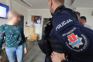 Na zdjęciu widoczny jest umundurowany policjant, na którego rękawie znajduje się naszywka: KPP w Zawierciu, Policja, Komisariat Policji w Szczekocinach oraz herb Szczekocin.