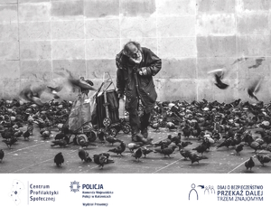 Czarno-białe zdjęcie przedstawiające osobę bezdomną karmiącą gołębie.